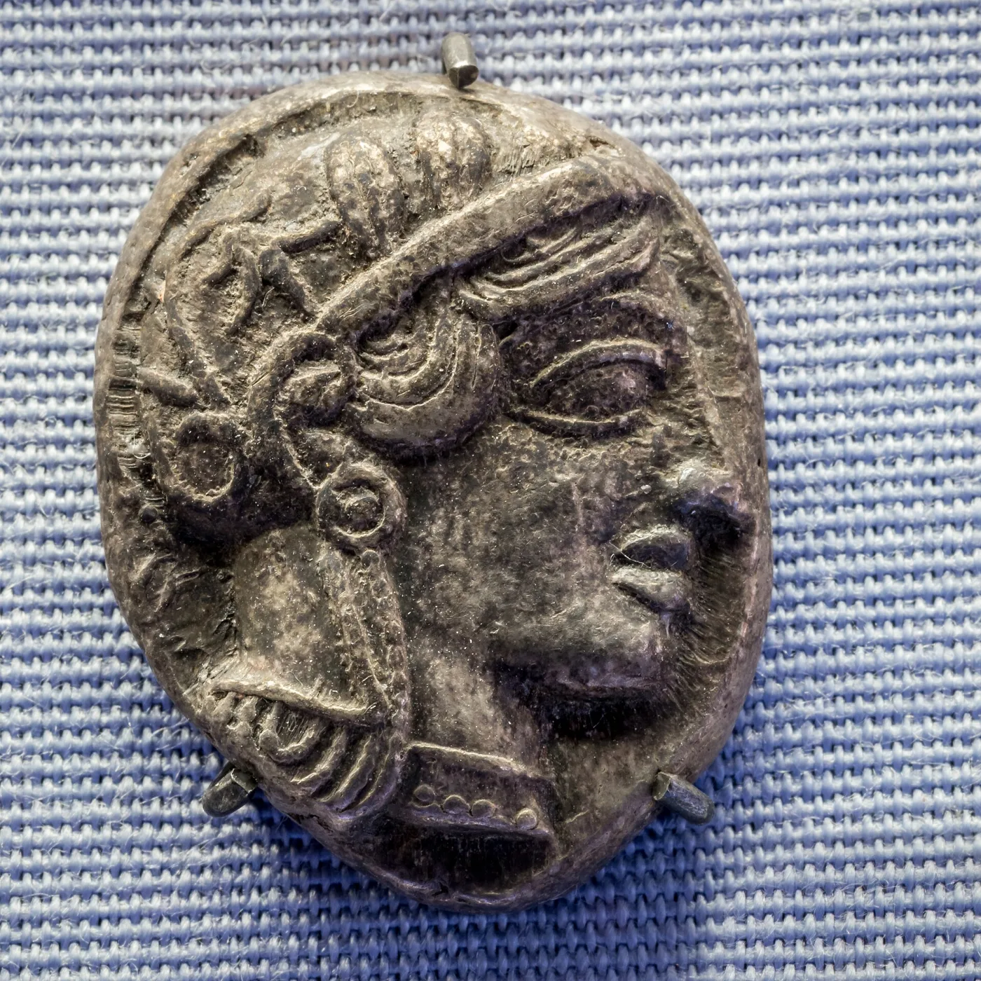 Obverse of an Athenian silver tetradrachm, helmeted head of Athena facing right with a large almond-shaped eye drawn as if seen from the front
