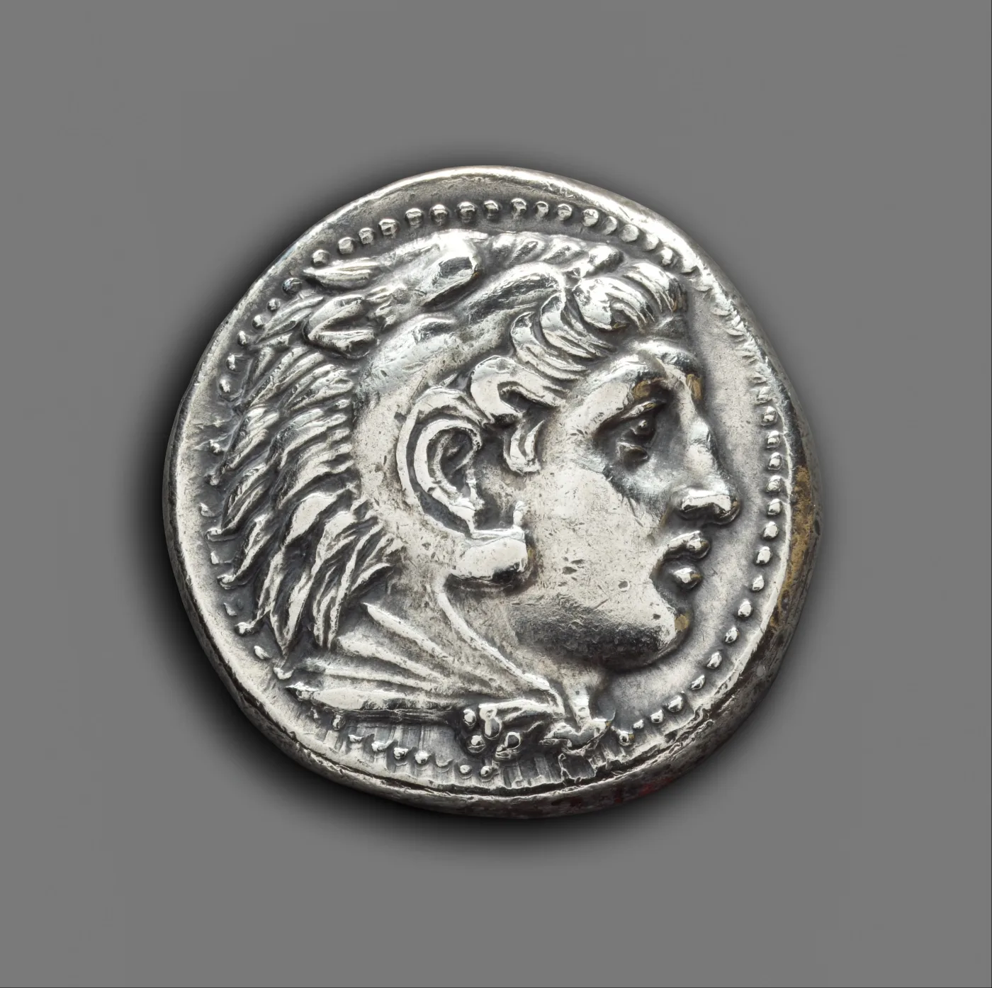 Obverse of a silver tetradrachm of Alexander the Great, the head of Herakles facing right wearing the scalp of the Nemean lion