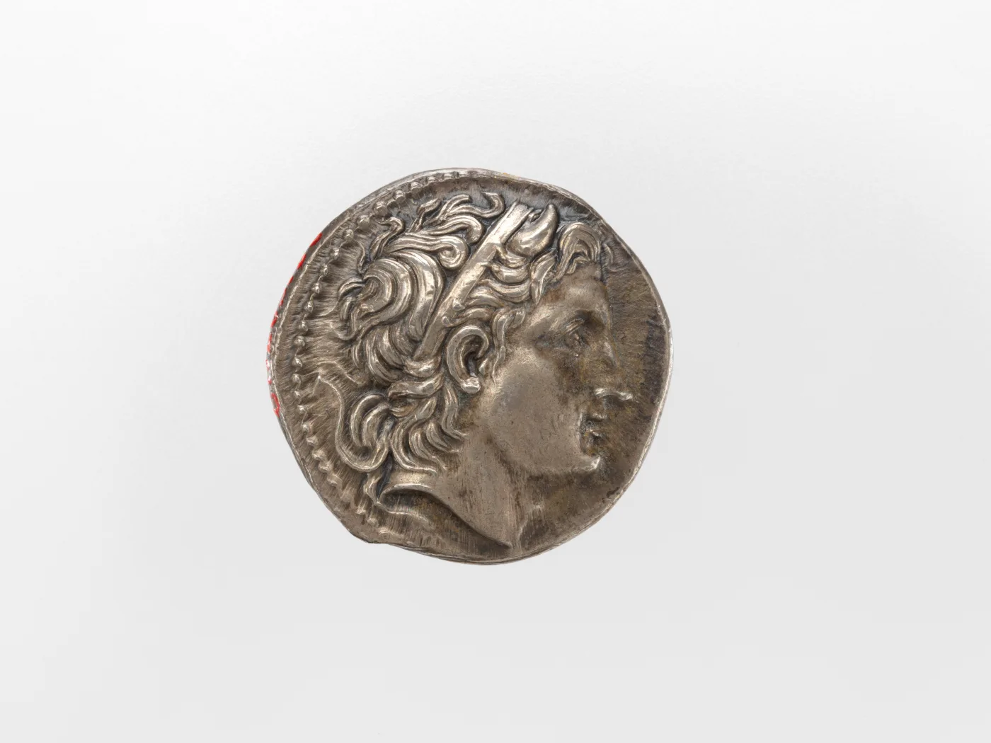 Silver tetradrachm of Demetrios Poliorketes, a diademed head facing right with a small curved bull's horn rising from the temple