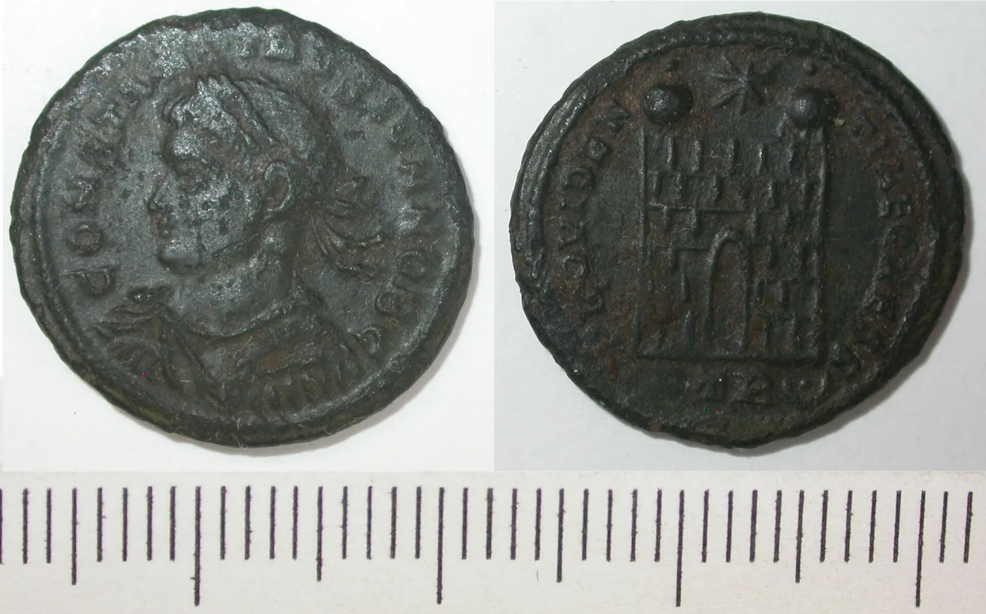 Obverse and reverse of a Roman copper-alloy nummus, the reverse showing a camp gate with two turrets, a star above and a short inscription in the exergue below