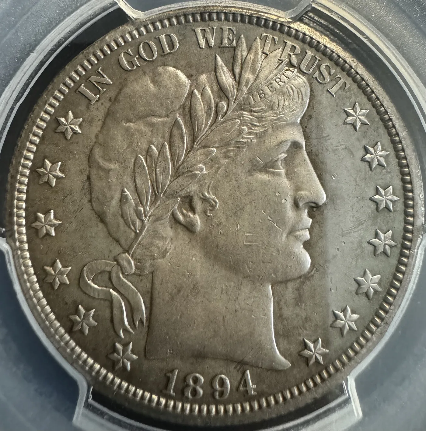 Close-up obverse of a circulated 1894-O Barber half dollar showing the LIBERTY headband with the letters weak and partly merged