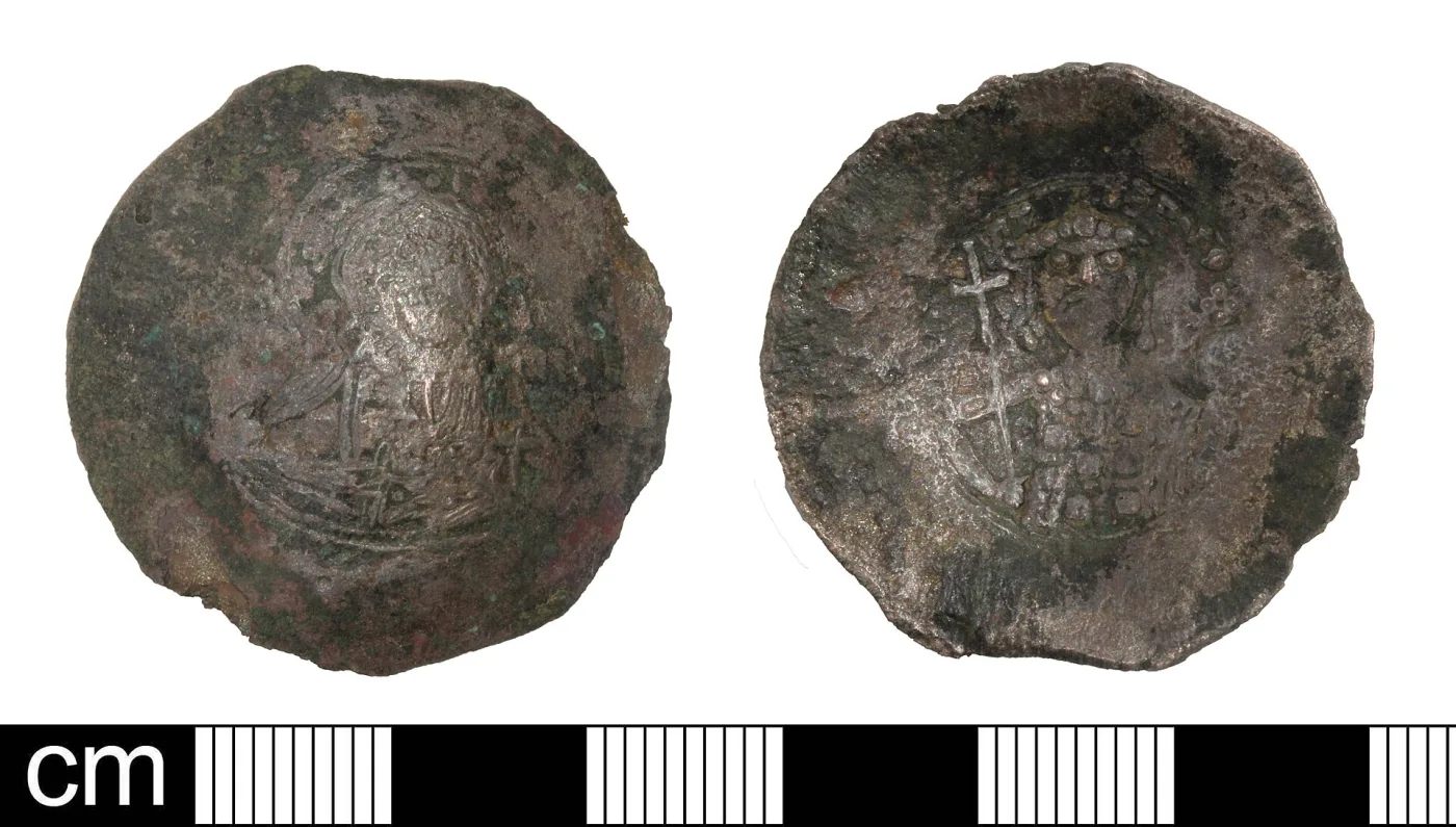 Obverse and reverse of a worn, dished Byzantine coin, the surface curving away from the viewer on one side