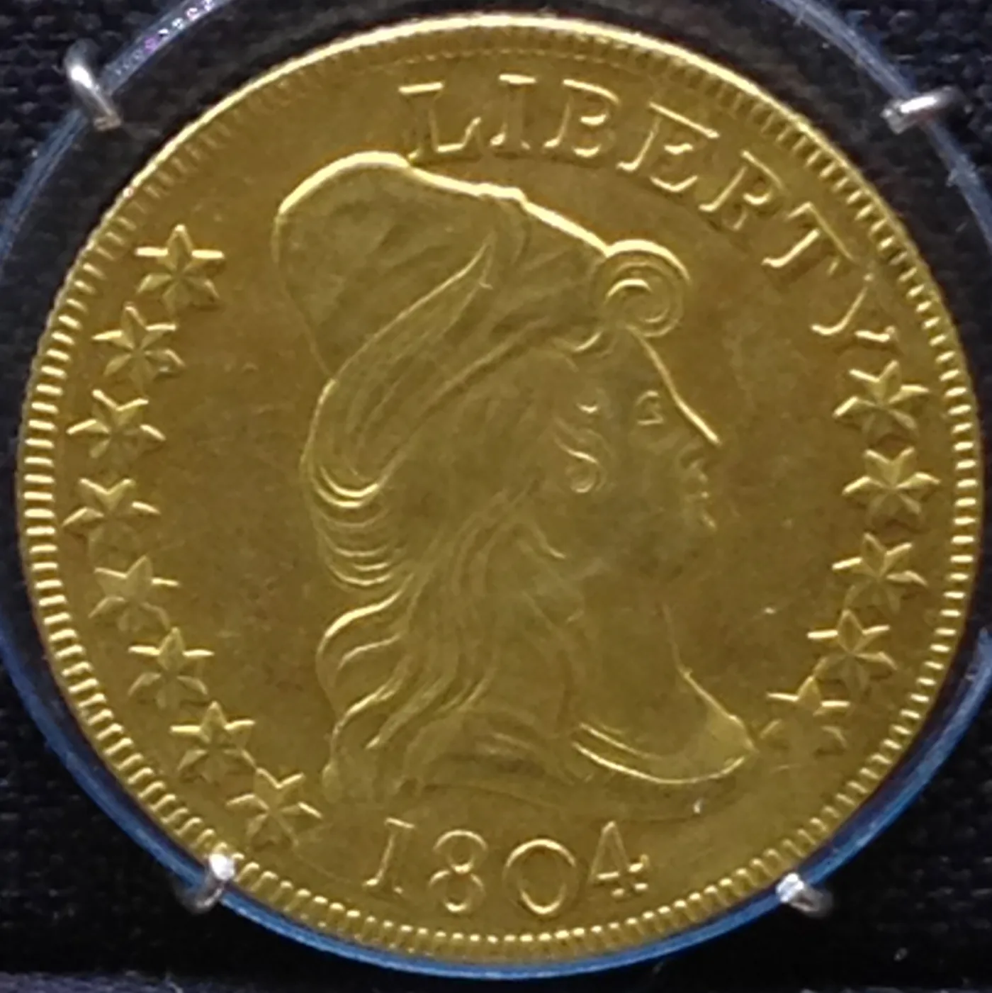 Obverse of a gold eagle dated 1804 sealed in a certified plastic holder, the date legible below the bust