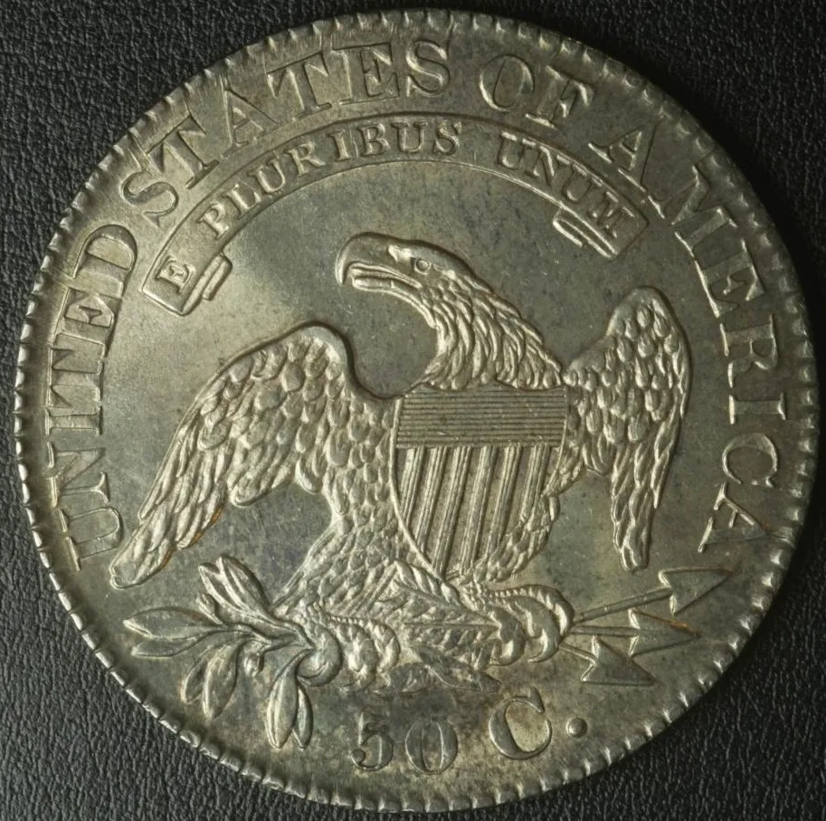 Reverse of an 1828 Capped Bust half dollar showing the heraldic eagle, the shield, the E PLURIBUS UNUM scroll and the 50 C. denomination