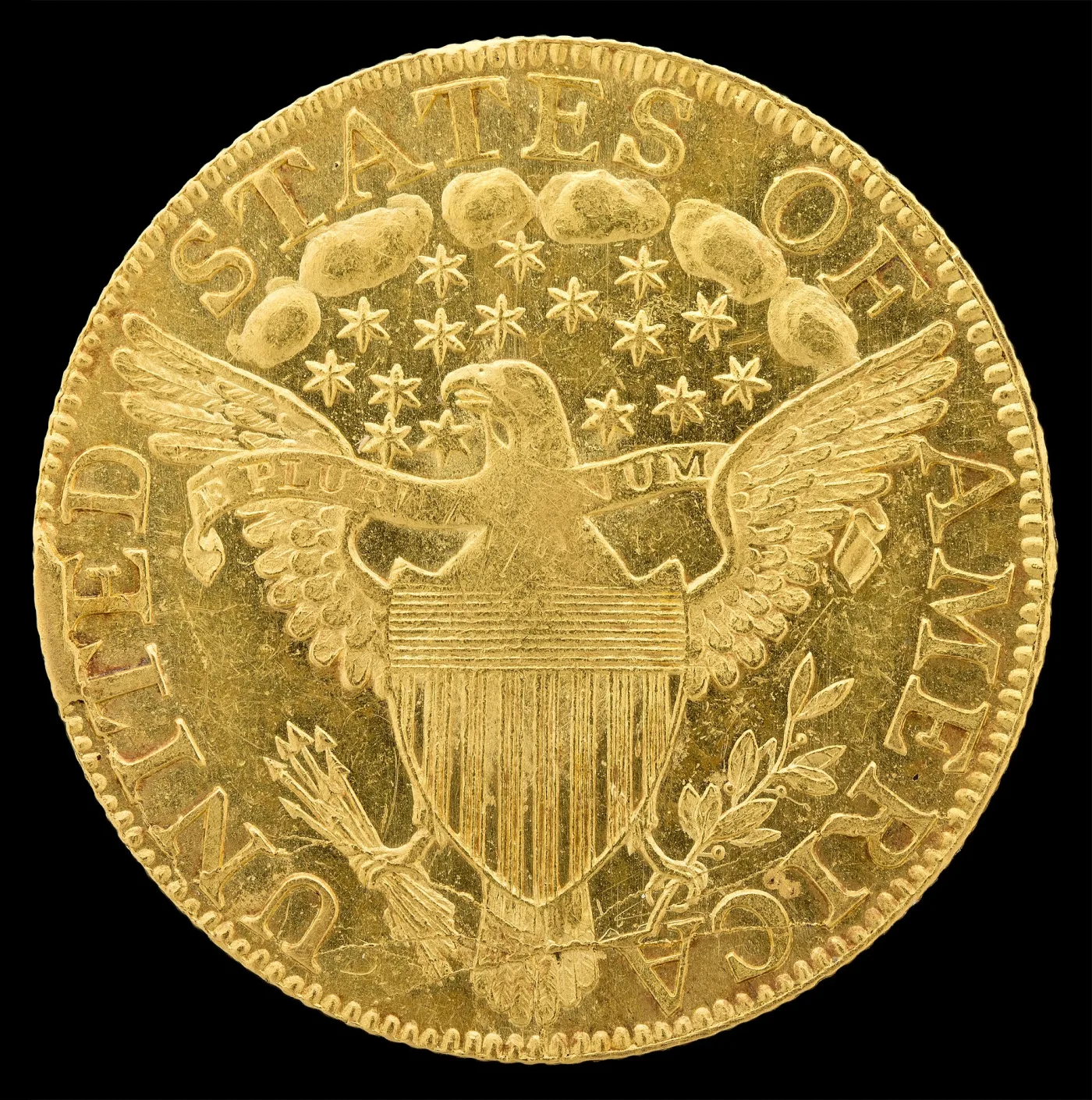 Heraldic eagle reverse of a 1795 half eagle with a shield on the eagle's breast, an E PLURIBUS UNUM scroll and a cluster of stars and clouds above