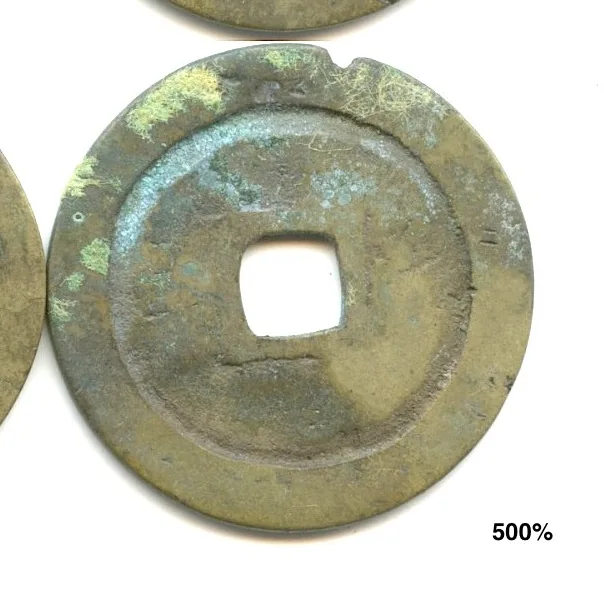 A Chinese cash coin whose surface carries patches of pale green and blue crust, the characters partly obscured