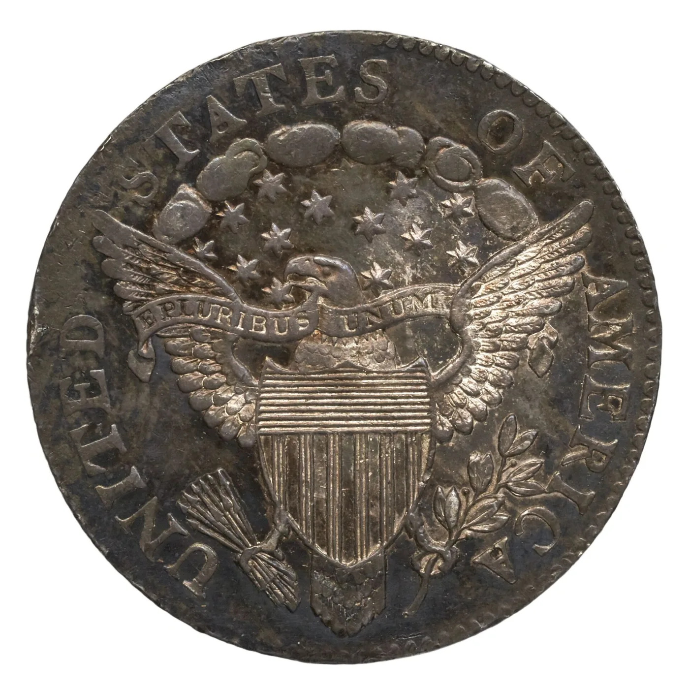 Reverse of an 1804 Draped Bust dime showing a heraldic eagle with a striped shield on its breast, a banner reading E PLURIBUS UNUM, arrows and an olive branch in its talons and a cluster of stars and clouds above