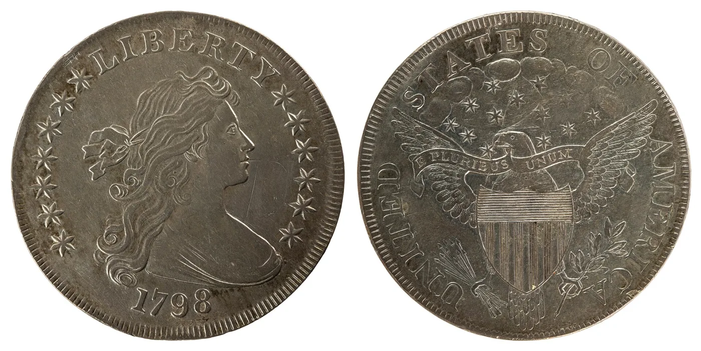 A 1798 Draped Bust dollar photographed obverse and reverse, the reverse showing a heraldic eagle with a striped shield and the motto E PLURIBUS UNUM on a banner