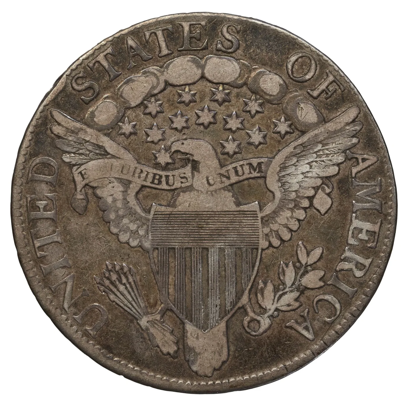 Heraldic Eagle reverse of an 1806 half dollar, a large spread-winged eagle with a striped shield on its breast, arrows and an olive branch in its talons and E PLURIBUS UNUM on a ribbon