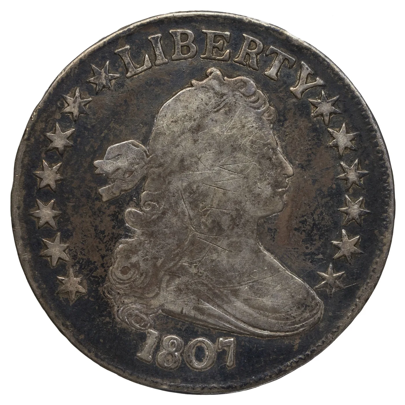 Obverse of an 1807 Draped Bust half dollar with the date 1807 below the bust, stars around the rim and heavy dark toning in the fields