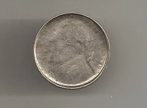 A silver coin whose rim has folded upward into a shallow collar, the central design almost entirely flattened away