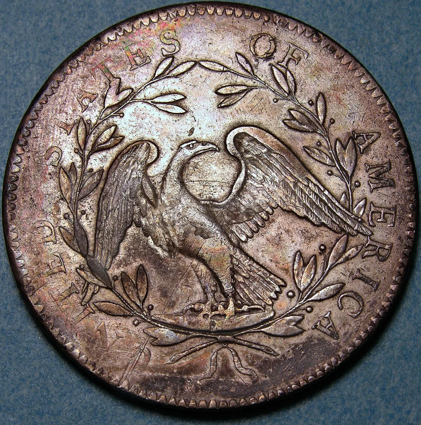 Reverse of the same 1794 Flowing Hair dollar showing the small eagle, open wreath and weakness at the right periphery