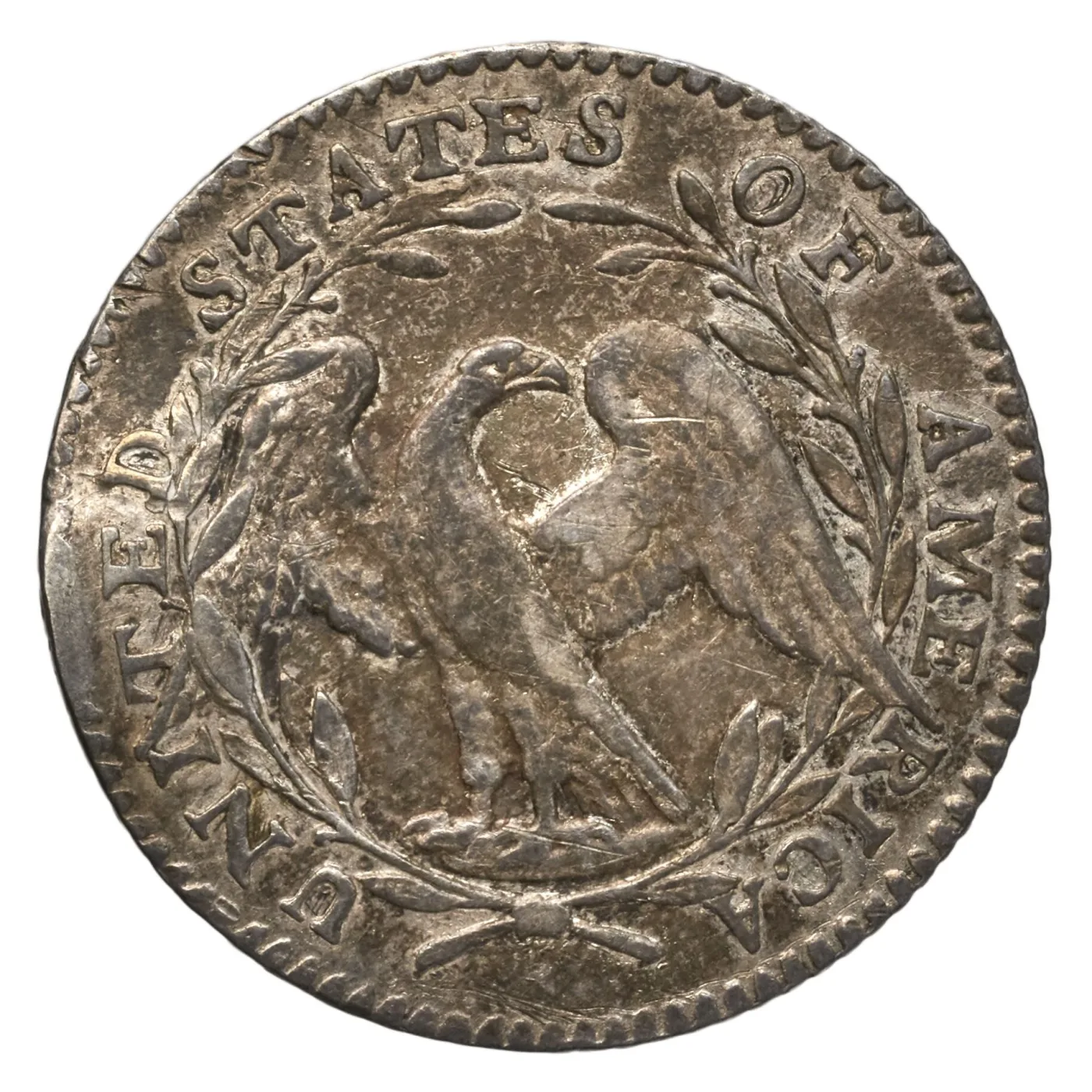 Reverse of a 1795 Flowing Hair half dime showing a small eagle within an open wreath and UNITED STATES OF AMERICA around the rim, with no denomination anywhere on the coin
