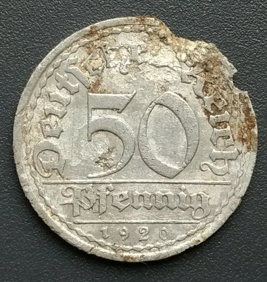 Corroded aluminium 50 pfennig of 1920 showing the value 50 Pfennig in Fraktur lettering with Deutsches Reich around the rim and the date below