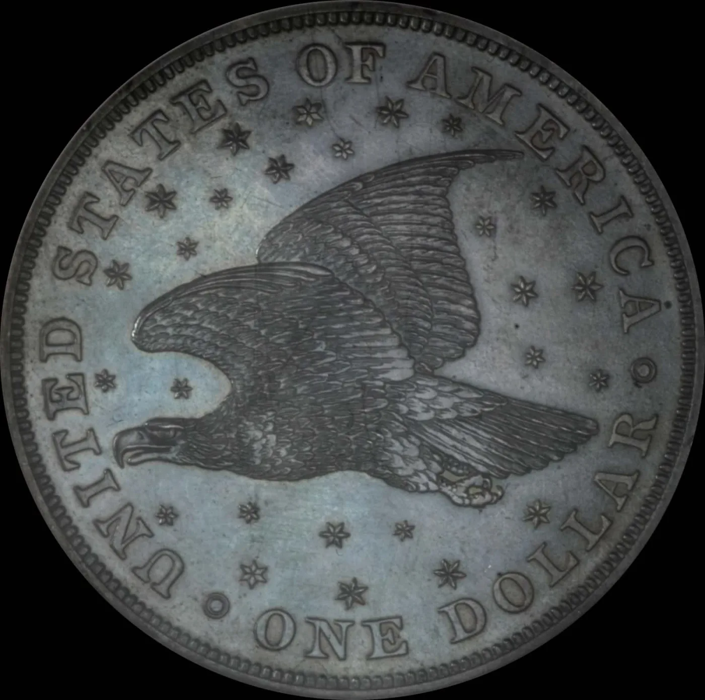 Reverse of an 1836 Gobrecht dollar showing an eagle in flight surrounded by a field of stars, with UNITED STATES OF AMERICA above and ONE DOLLAR below