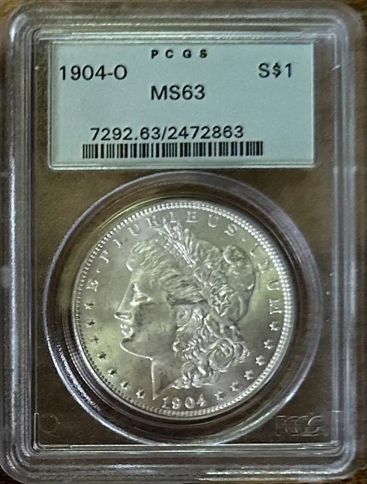 Front of a PCGS holder containing a 1904-O Morgan dollar, the label reading 1904-O S$1 MS63 above a certification number and barcode