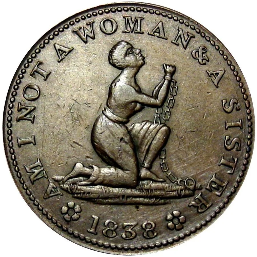 One side of a hard times token showing a kneeling woman in chains with raised clasped hands, the legend AM I NOT A WOMAN & A SISTER and the date 1838