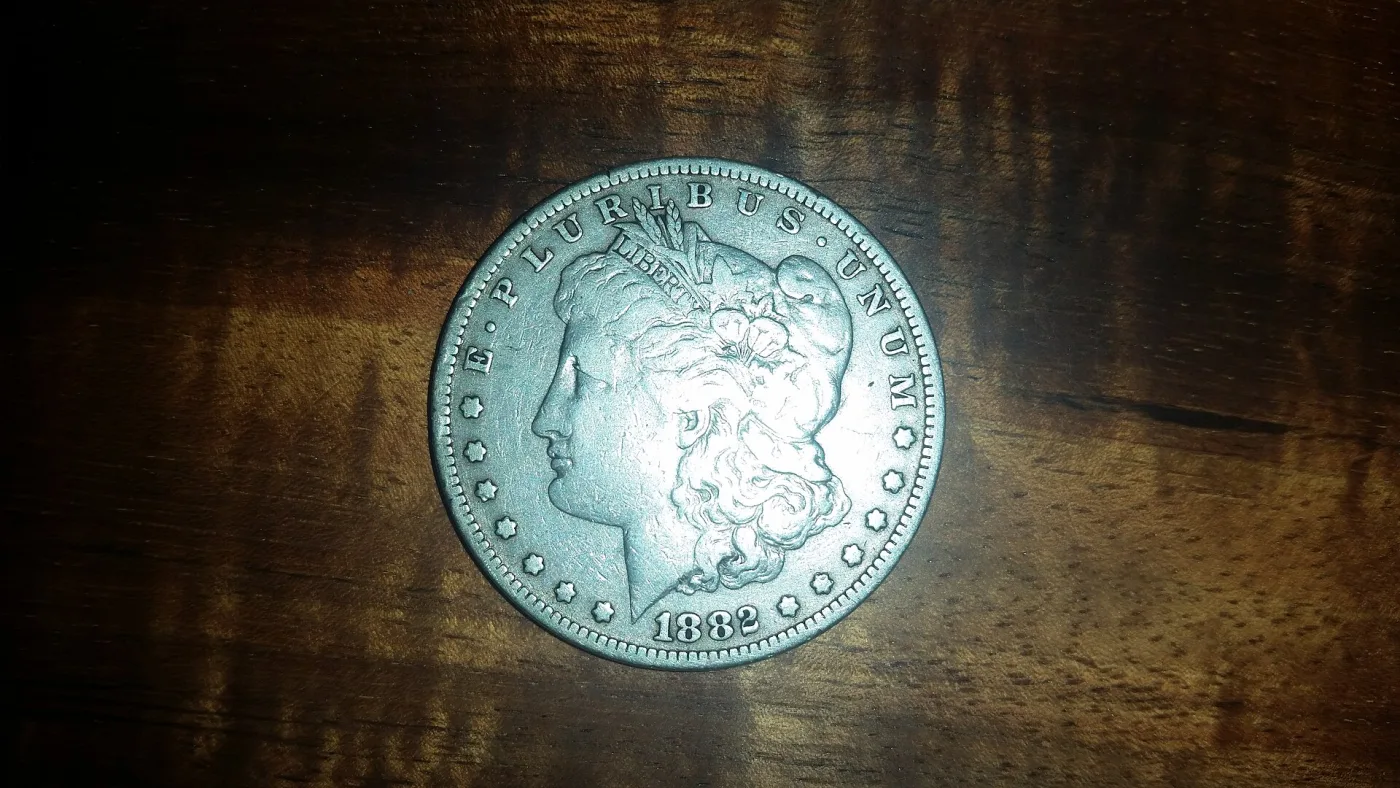Obverse and reverse of a circulated 1882 Morgan silver dollar