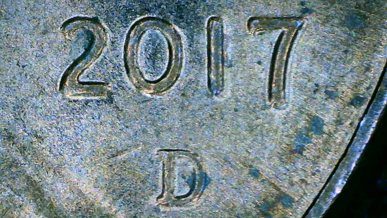 Extreme close-up of the lower right of a Lincoln cent obverse, showing the four digits of the date and a small mint letter beside them