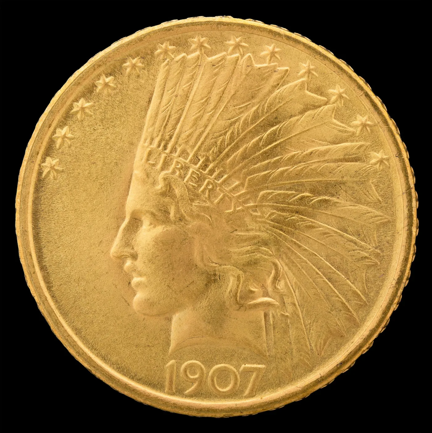 Obverse of a 1907 Indian Head eagle with LIBERTY raised on the headdress band, thirteen stars around the rim and the date below the bust