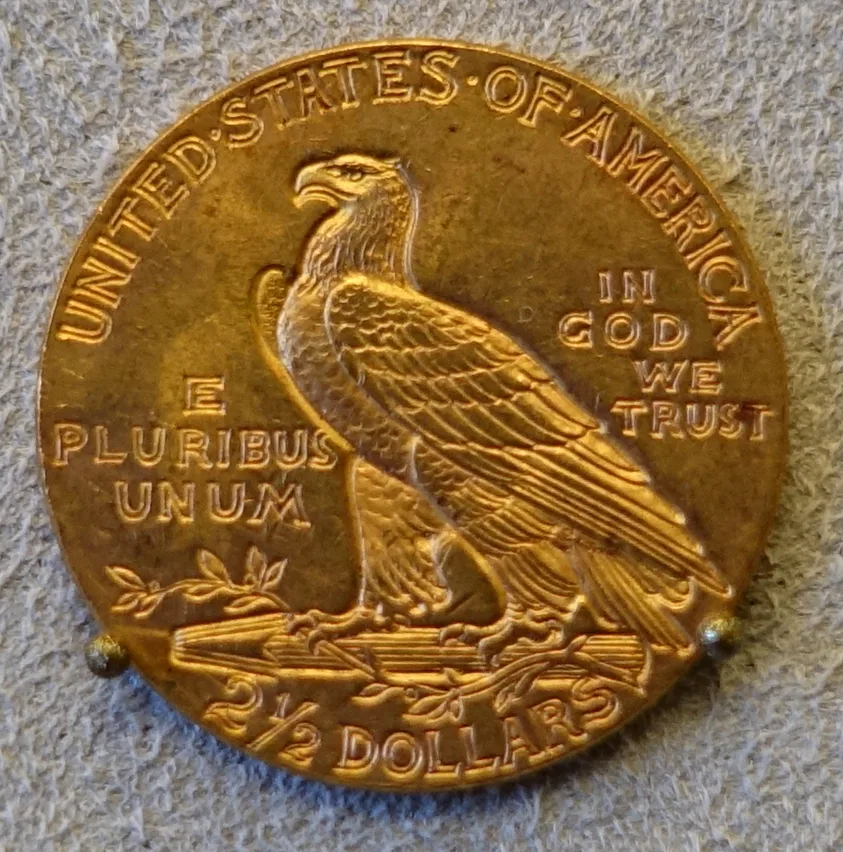 Reverse of an Indian Head quarter eagle held in a museum display mount, reading 2 and a half DOLLARS below the eagle, with bare field where a mint mark would sit to the left of the arrow bundle