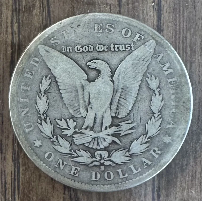 Reverse of the same 1893-S Morgan dollar showing an eagle with outstretched wings and a small S mint mark below the wreath