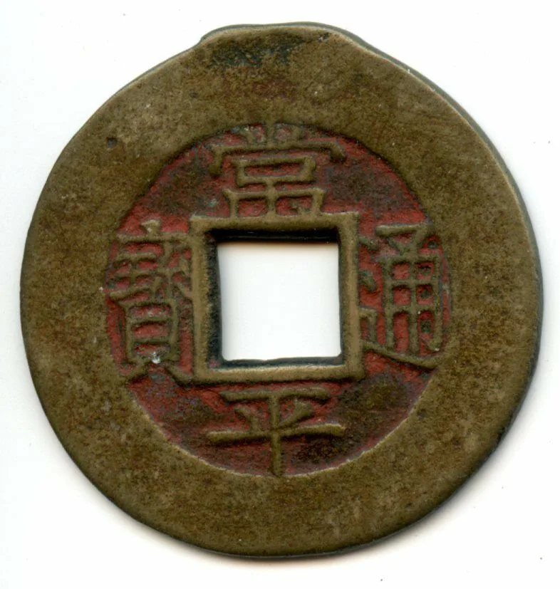 A round brass Korean coin with a square central hole and four sharply cast Chinese characters arranged around it