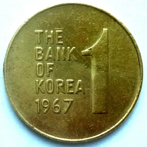Value side of a brass South Korean coin reading THE BANK OF KOREA and 1967 in Latin capitals beside a large numeral 1