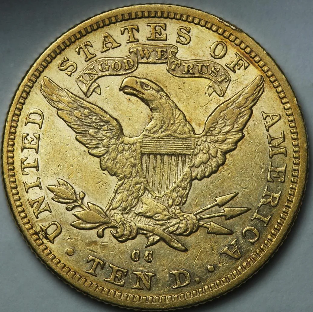 Reverse of an 1883-CC Liberty Head Eagle showing the IN GOD WE TRUST scroll above the eagle and a double-letter CC mint mark below the tail feathers