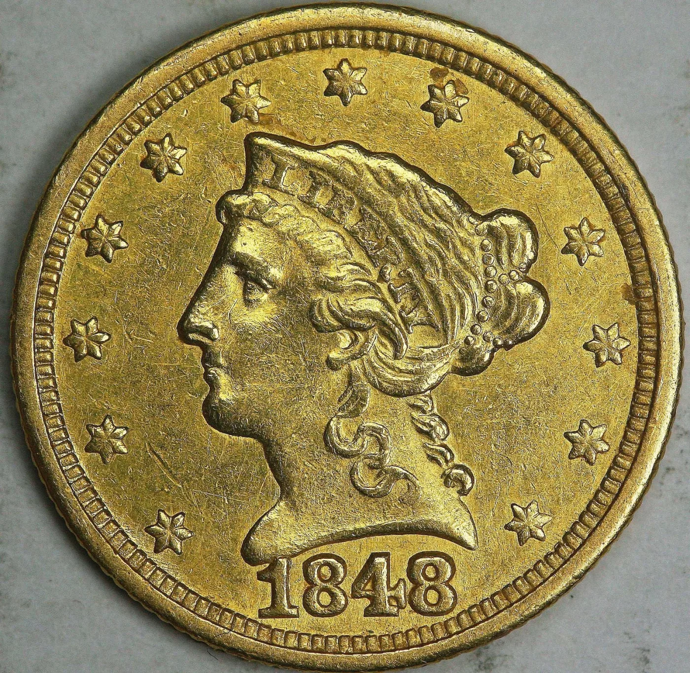 Obverse of an 1848 Liberty Head Quarter Eagle showing Liberty facing left in a coronet lettered LIBERTY, thirteen stars around the rim and the date 1848 below the bust