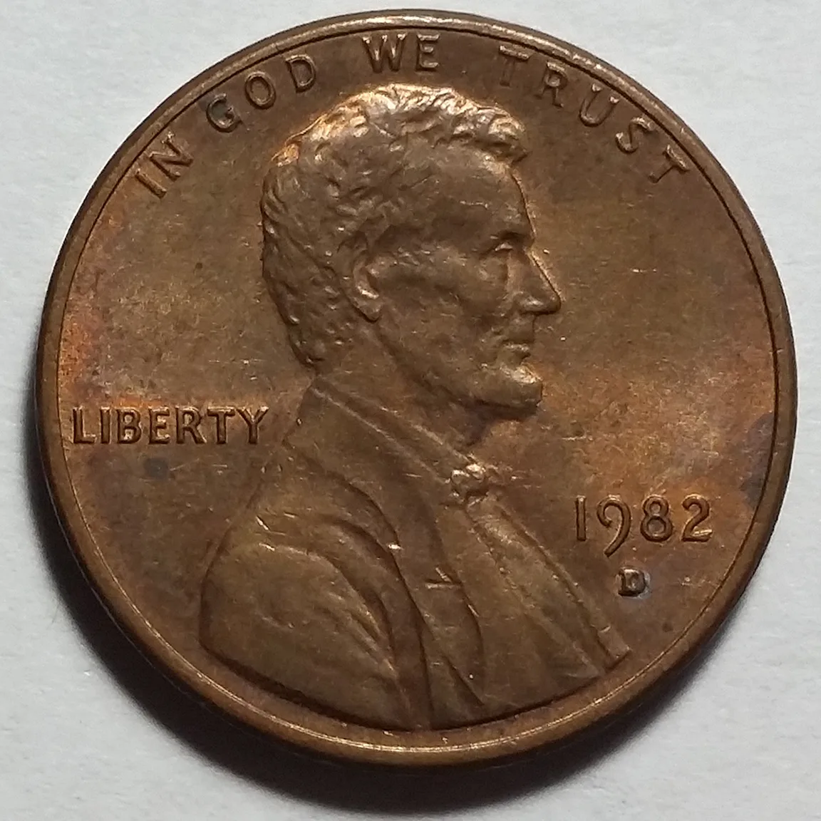 Obverse of a 1982-D Lincoln cent of the Small Date style, the digits of 1982 noticeably slimmer with a lighter, thinner 2