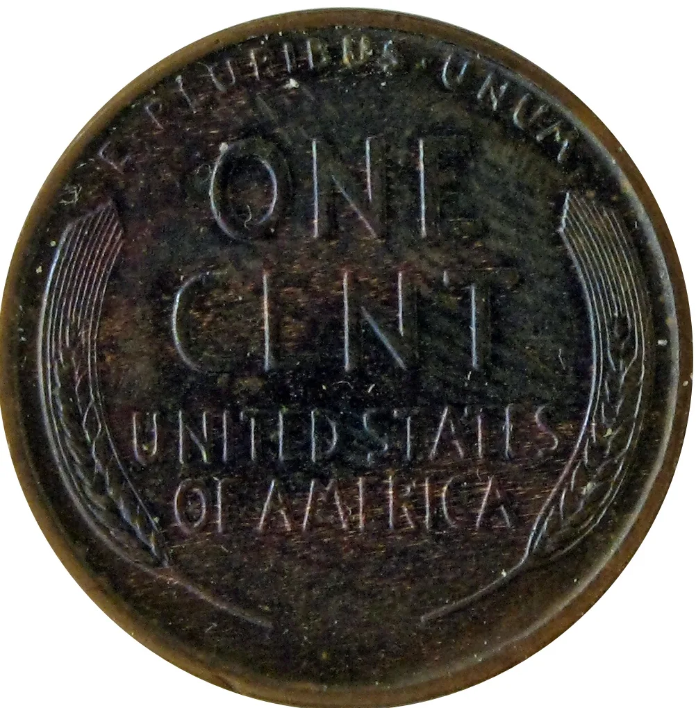 Reverse of a 1928 Lincoln wheat cent toned almost black, with the wheat stalks and lettering still fully readable