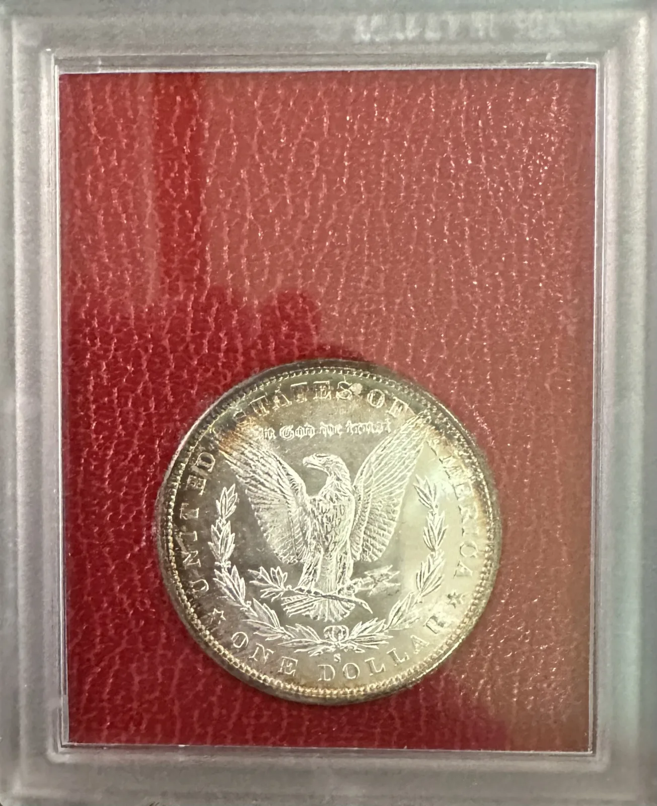 An 1880-S Morgan dollar reverse sealed in an old plastic holder with red backing, sold from the Redfield Hoard