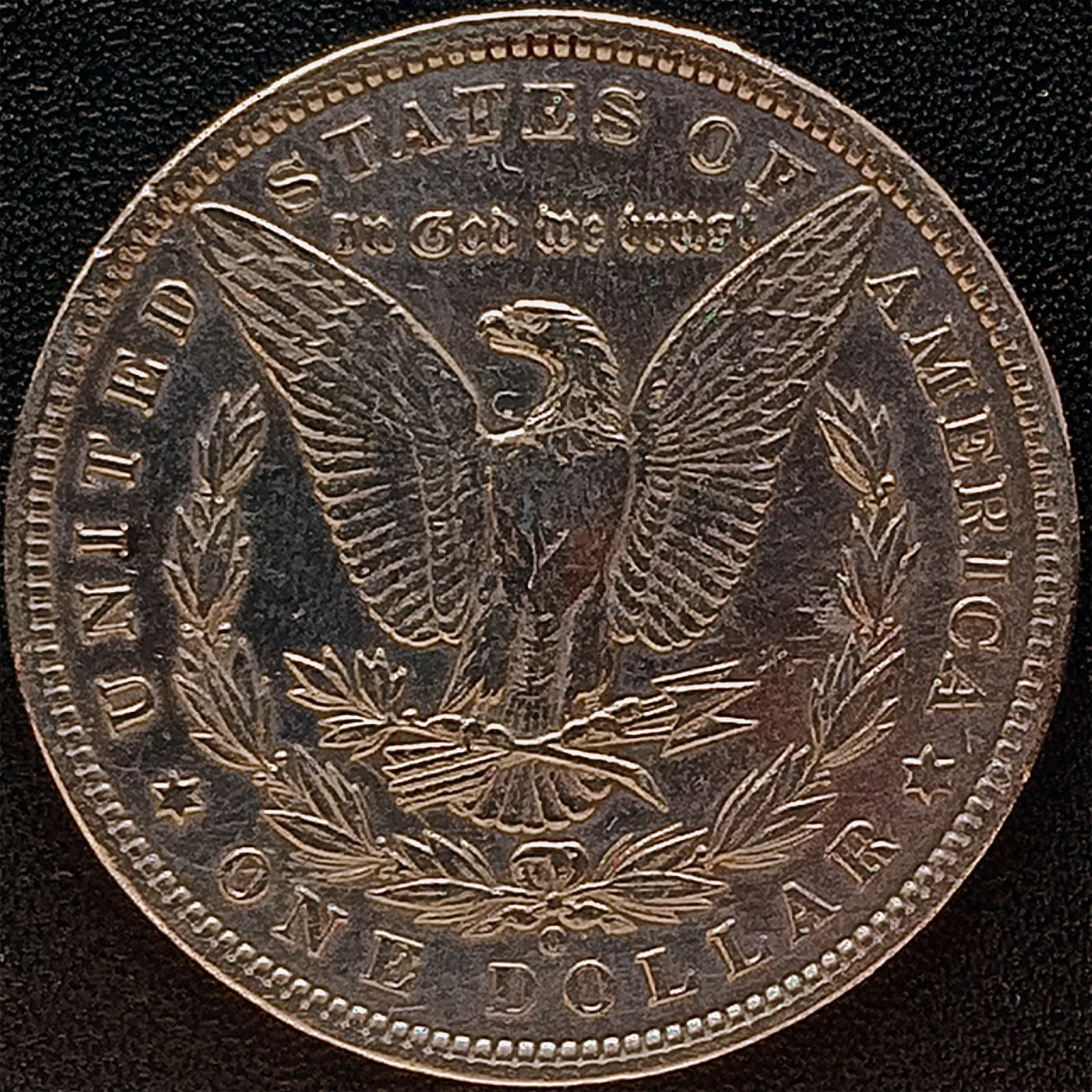 Reverse of a Morgan dollar with a soft, rounded O mint mark in the field below the wreath bow