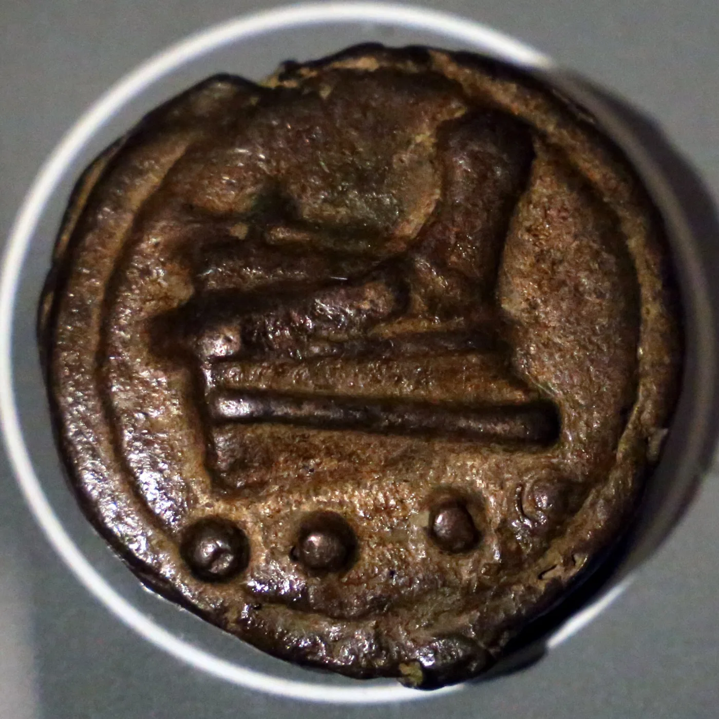 Reverse of a cast Roman bronze triens, a ship's prow above a row of raised pellets