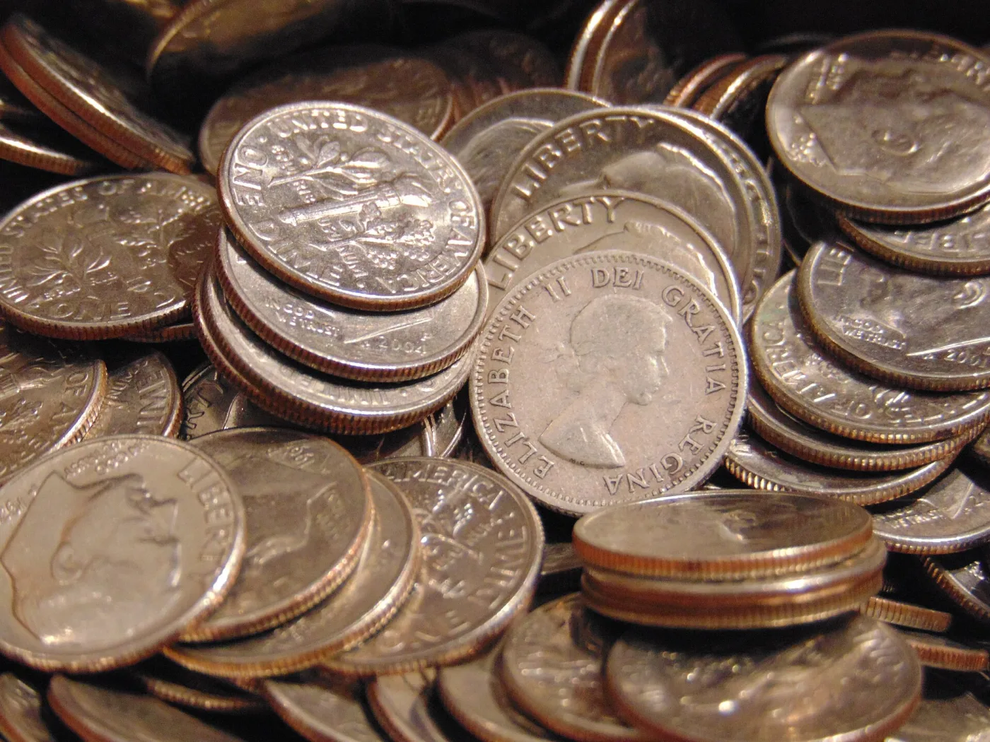 A box of loose United States dimes with a coin of Elizabeth II lying among them