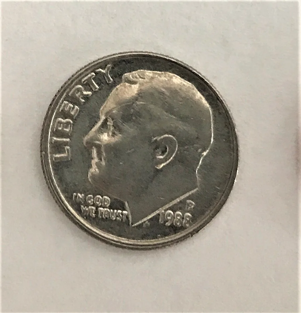 Obverse of a circulated Philadelphia Roosevelt dime showing wear on the cheek and the hair above the ear