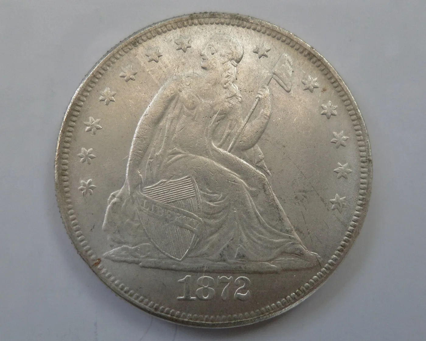 Obverse of a lightly circulated 1872 Carson City Seated Liberty dollar with the date below Liberty and no mint mark on this side