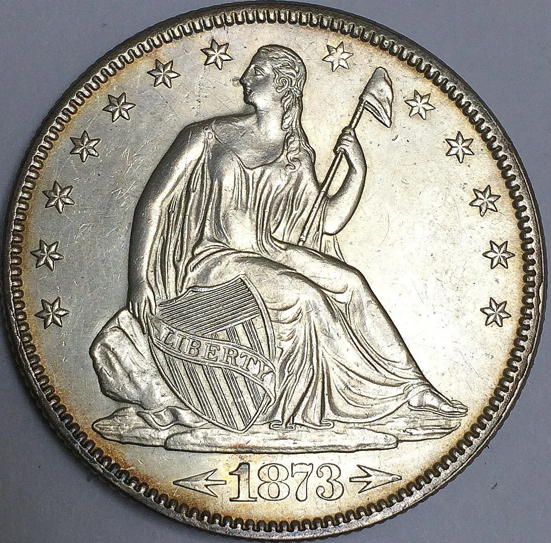 Obverse of an 1873 Seated Liberty half dollar with an arrow on each side of the date, a sharp LIBERTY on the shield ribbon and full gown detail