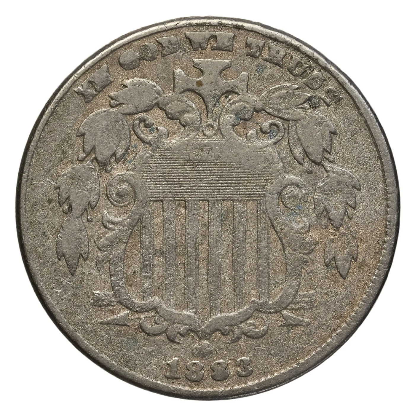 Obverse of a heavily circulated Shield nickel with IN GOD WE TRUST reduced to ghost letters, the shield flat and the olive leaves merged into blobs