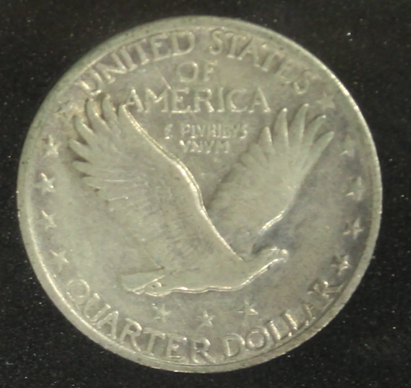Heavily circulated Standing Liberty quarter reverse where the eagle's feather detail is worn smooth but three stars remain visible below it