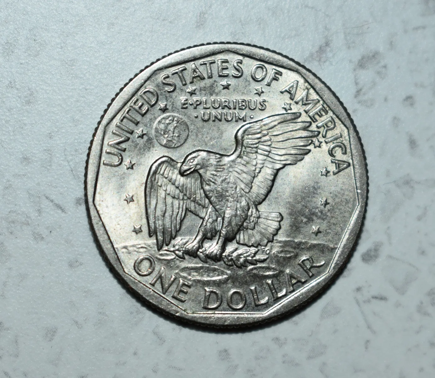 Reverse of a 1979 Susan B. Anthony dollar, the eleven-sided inner border plainly visible as a ring of straight edges inside the round rim