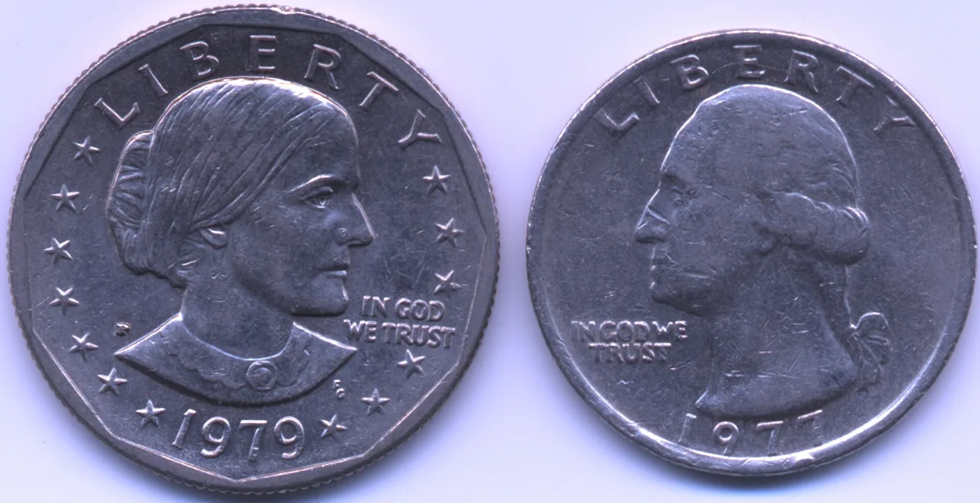 A 1979 Susan B. Anthony dollar lying beside a 1977 Washington quarter, the dollar only slightly larger and the same silver colour