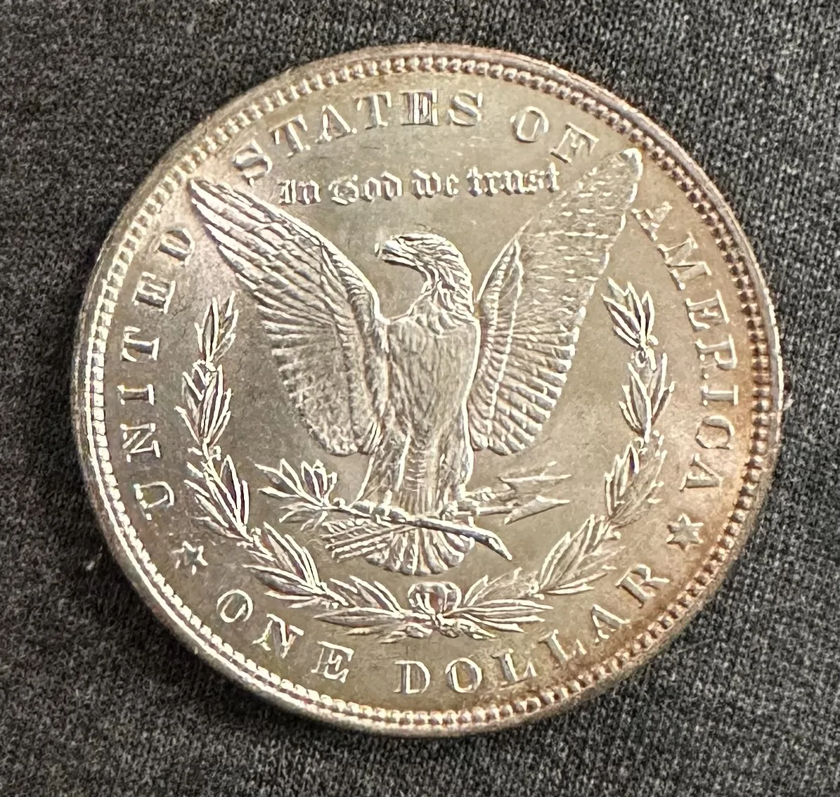 Obverse of a Morgan silver dollar, the centre bright and untoned and the outer edge carrying a band of darker colour