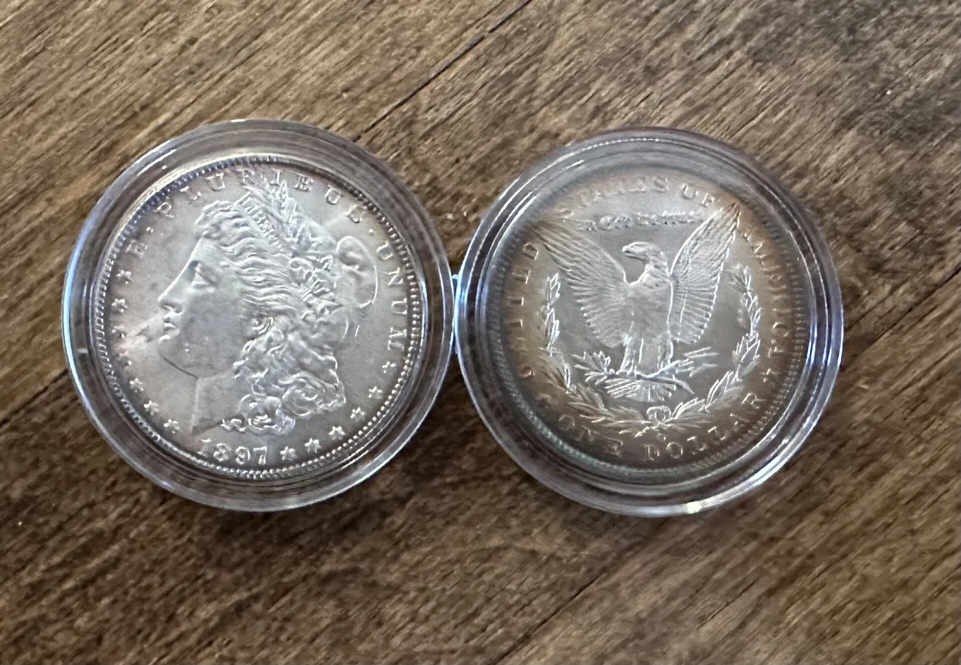 Several Morgan silver dollars together, each toned differently in bands of blue, gold and violet