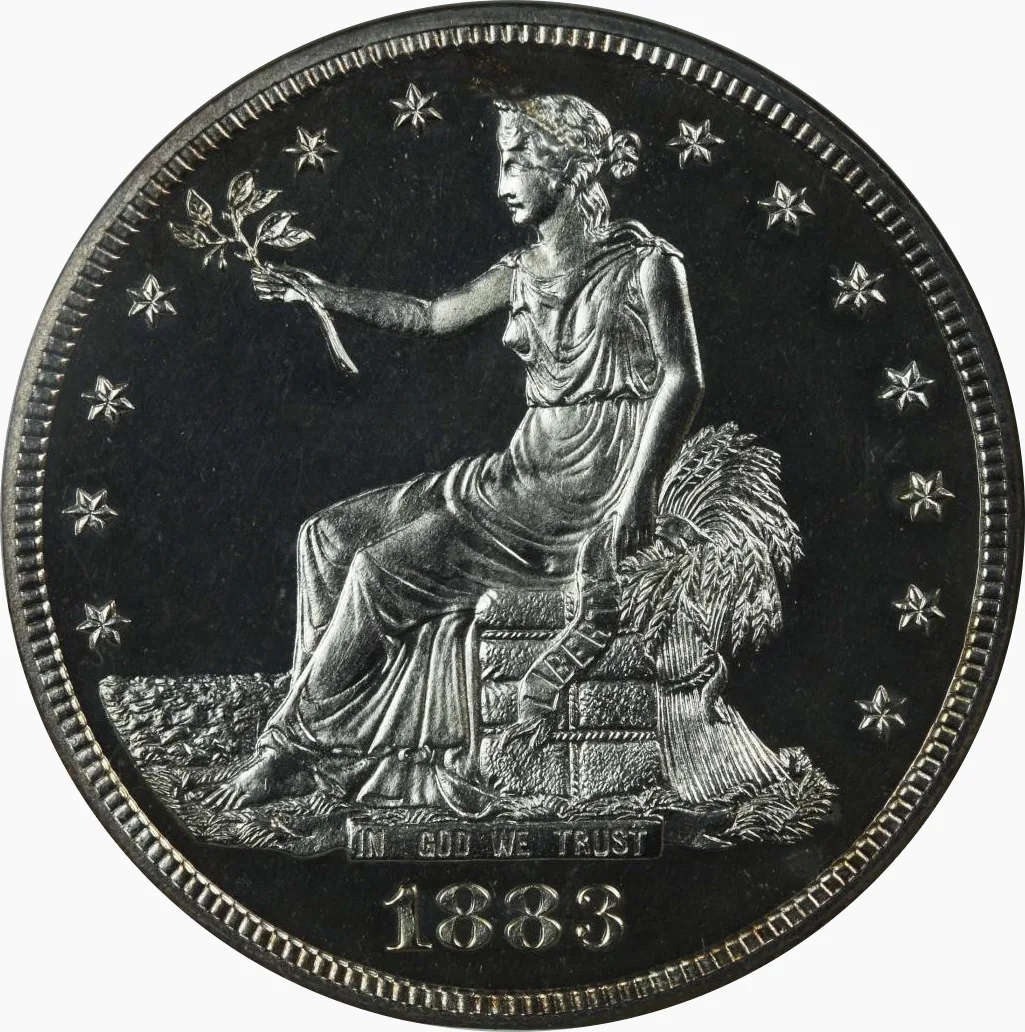 Obverse of an 1883 proof Trade Dollar showing Liberty seated on bales facing left, the LIBERTY scroll draped over the bales and IN GOD WE TRUST on the base below her feet