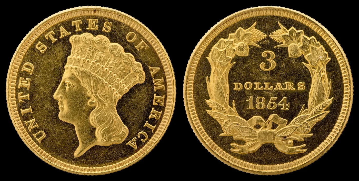 Obverse and reverse of an 1854 three-dollar gold piece, Liberty in a feathered headdress inside UNITED STATES OF AMERICA, and 3 DOLLARS 1854 inside an agricultural wreath
