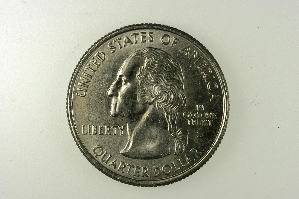 Obverse of a 2006-D Nebraska state quarter with UNITED STATES OF AMERICA above, QUARTER DOLLAR below, LIBERTY at the left and the D mint mark beside the hair ribbon